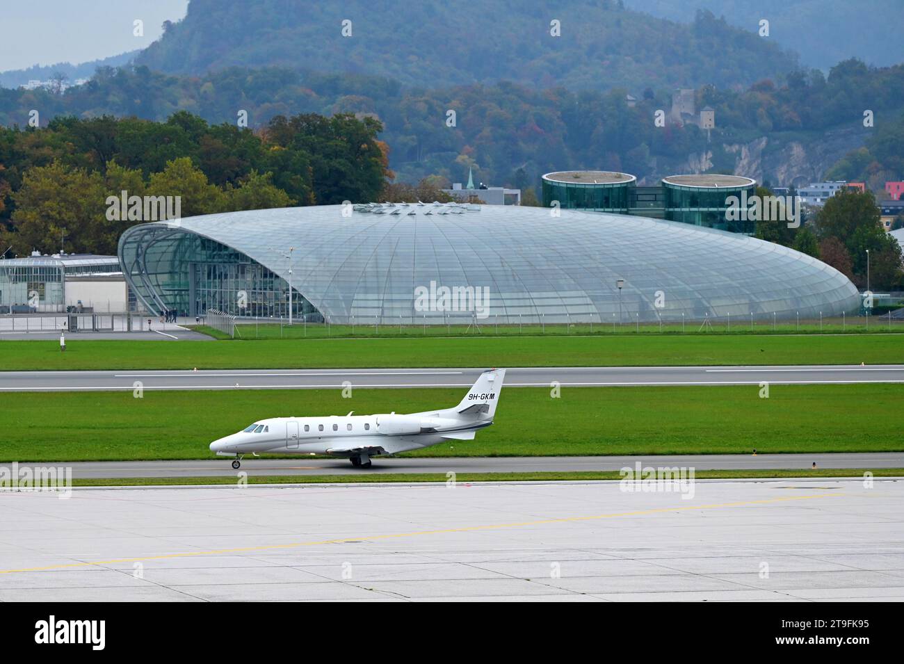 Airplane landing at the Salzburg Airport in Austria, in the background Hangar 7 Stock Photo