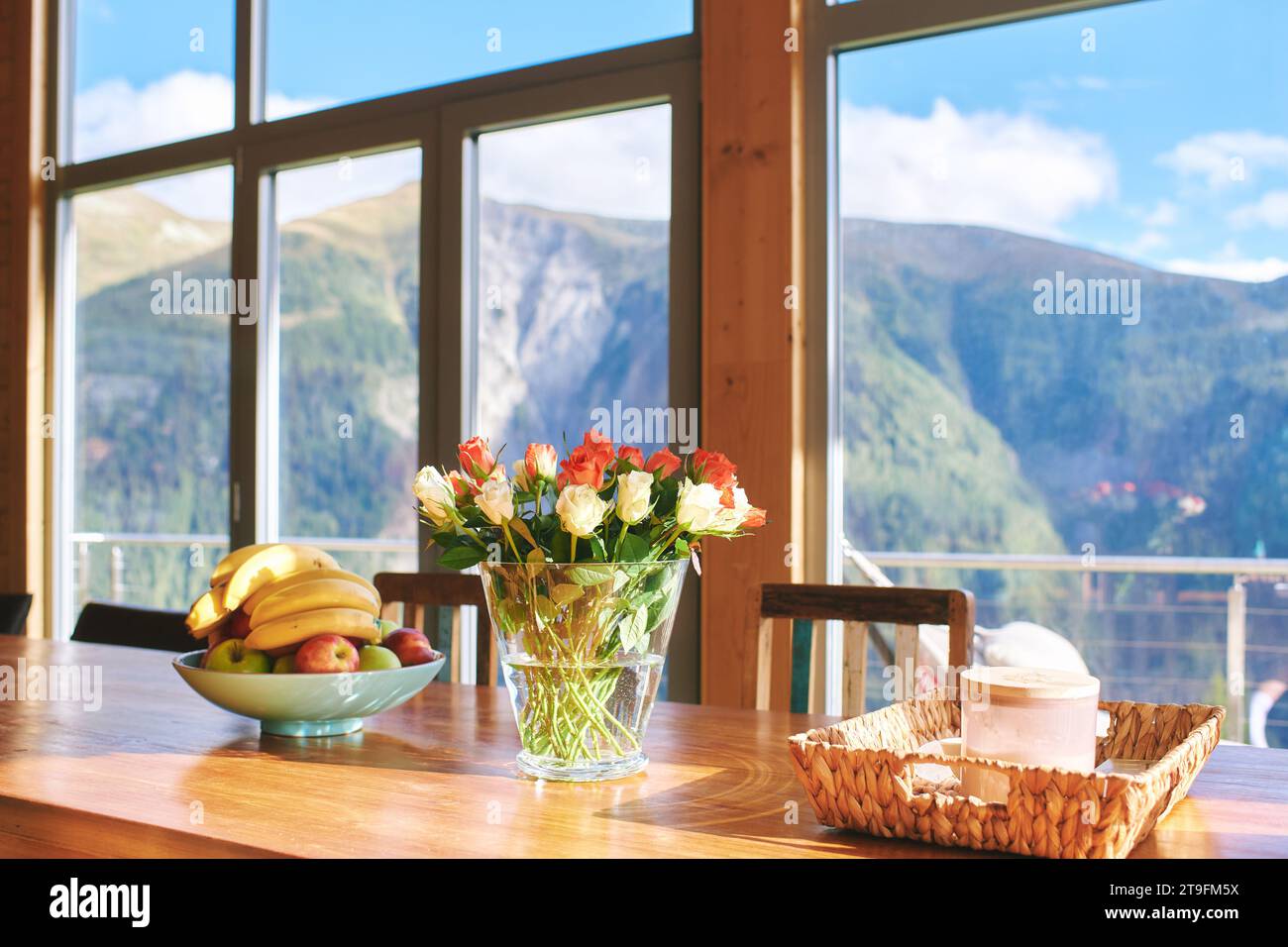 Dining table with colorful roses and banana bowl, mountain resort Stock Photo