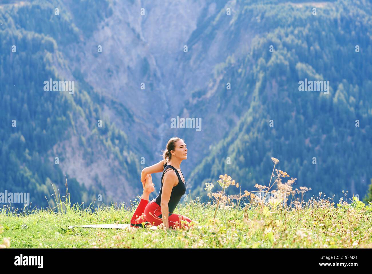 Outdoor portrait of healthy woman practicing yoga in mountains Stock Photo
