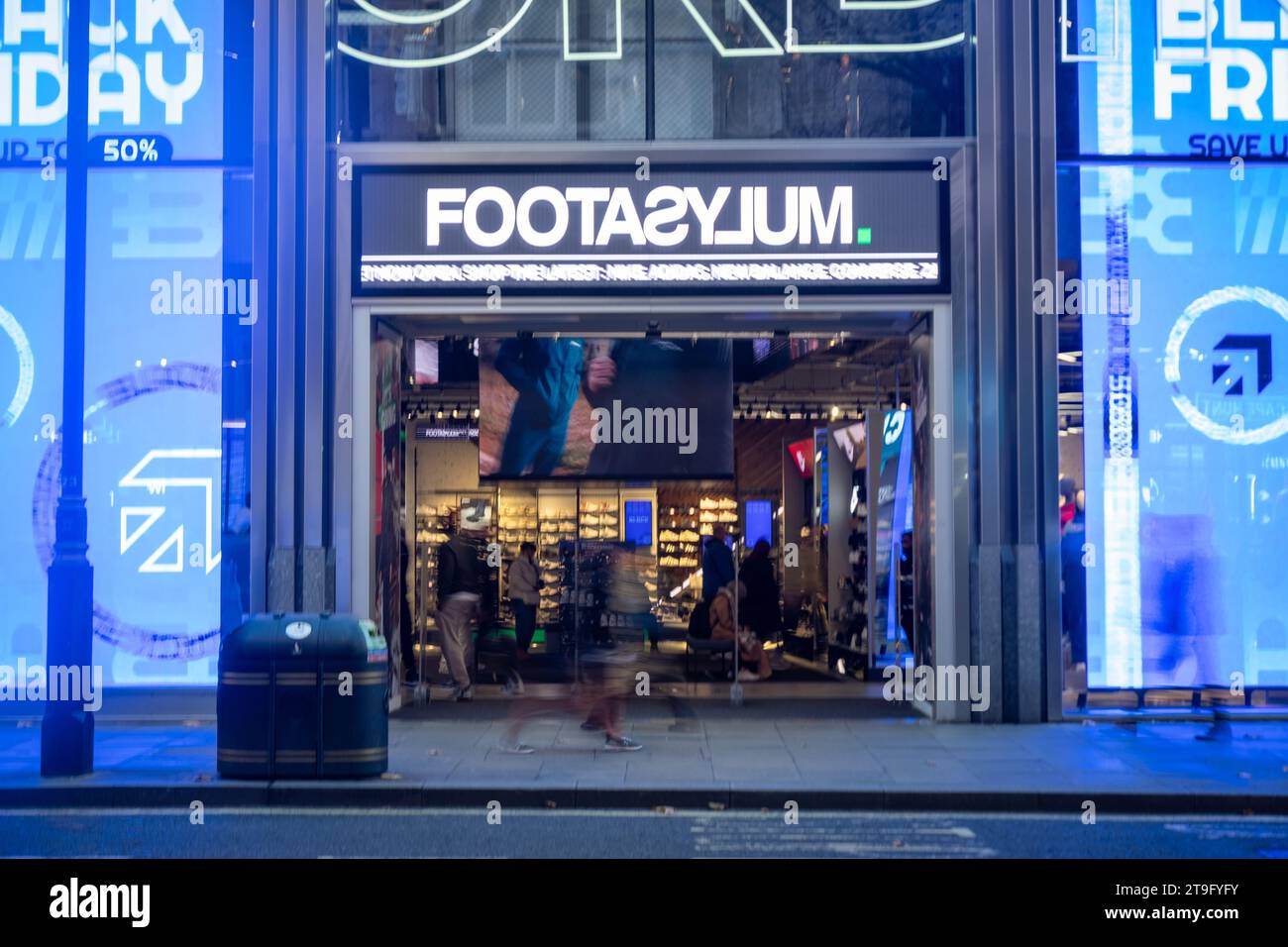 LONDON- NOVEMBER 23, 2023: Footasylum shoe shop and motion blurred shoppers on Oxford Street, landmark retail destination Stock Photo