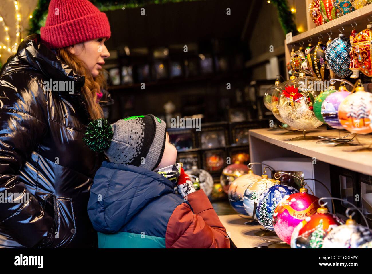 People walk the Christmas Market alees in Krakow, one of the largest such markets in Europe as it opens with hand mades gifts, Christmas lights, fresh food and hot wine on the landmark Main Square of the Old Town of Krakow, Poland on November 23, 2023. Stock Photo