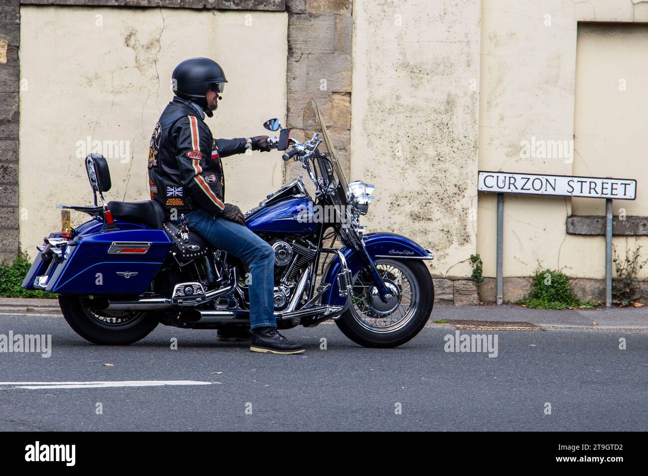 Biker on a blue Harley Davidson motorbike at the Calne bike meet with Curzon Street sign in the background July 2023 Stock Photo