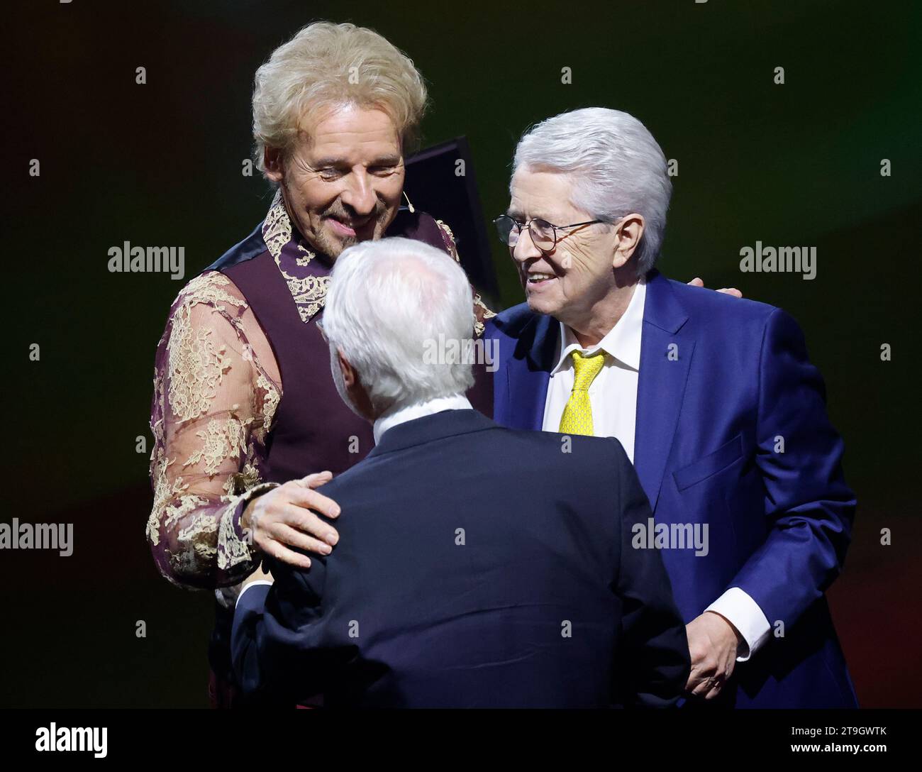 Offenburg, Germany. 25th Nov, 2023. Presenter Thomas Gottschalk (l) greets presenter Frank Elstner (r) and Markus Schächter, former director of Zweites Deutsches Fernsehen, before the start of the ZDF show 'Wetten, dass.?'. Gottschalk presents 'Wetten, dass.?' for the last time. After 36 years, he ends his career as a betting presenter on November 25. Credit: Philipp von Ditfurth/dpa/Alamy Live News Stock Photo