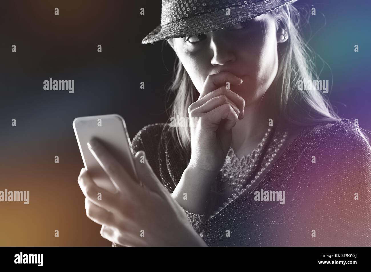Engrossed in her device, her finger thoughtfully at her lips, a modern ...