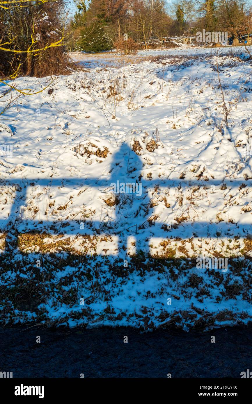 Silhouette, Schatten einer Frau und einem Brückengeländer im Schnee Stock Photo