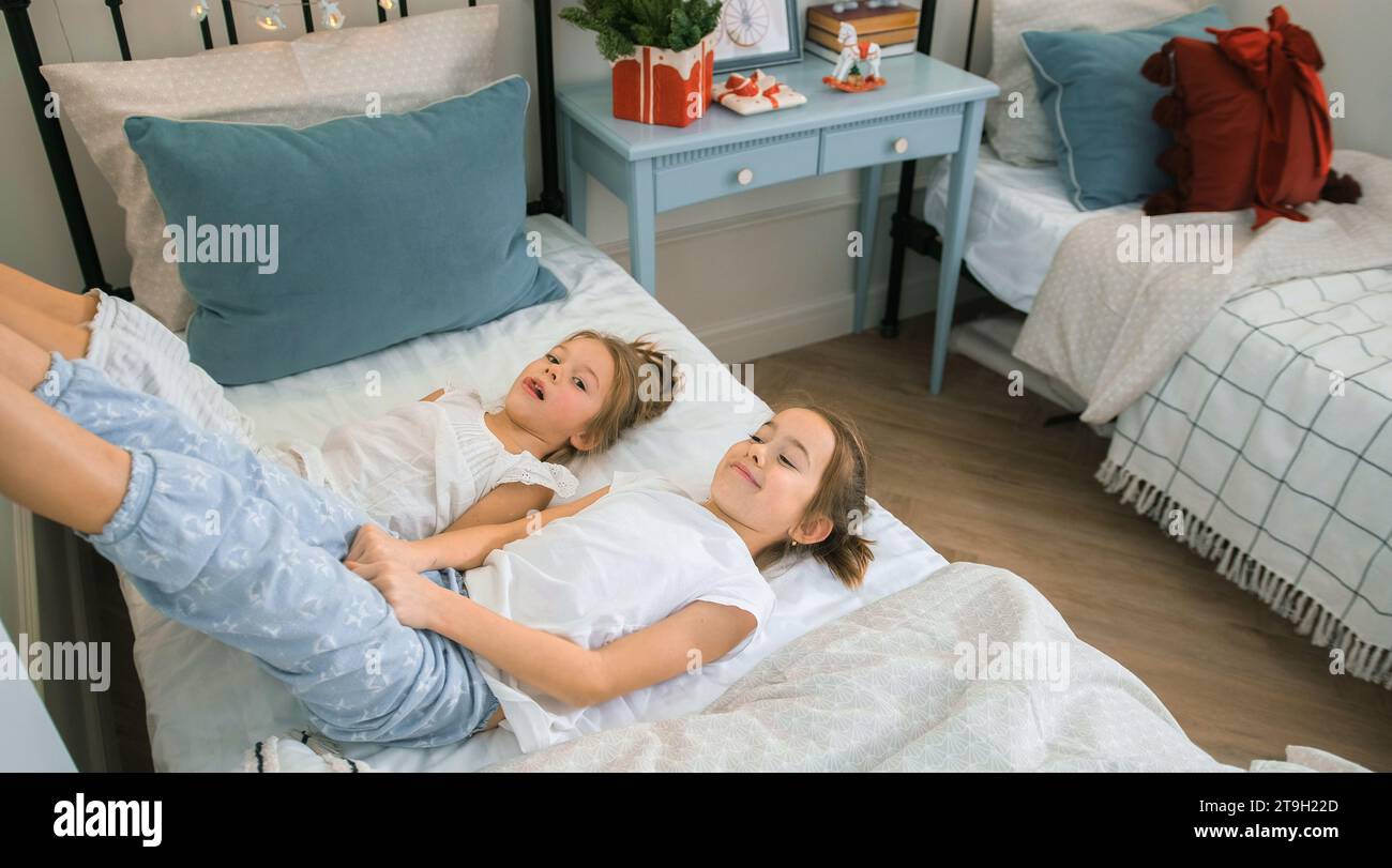 two little girls play on the bed in the nursery Stock Photo - Alamy