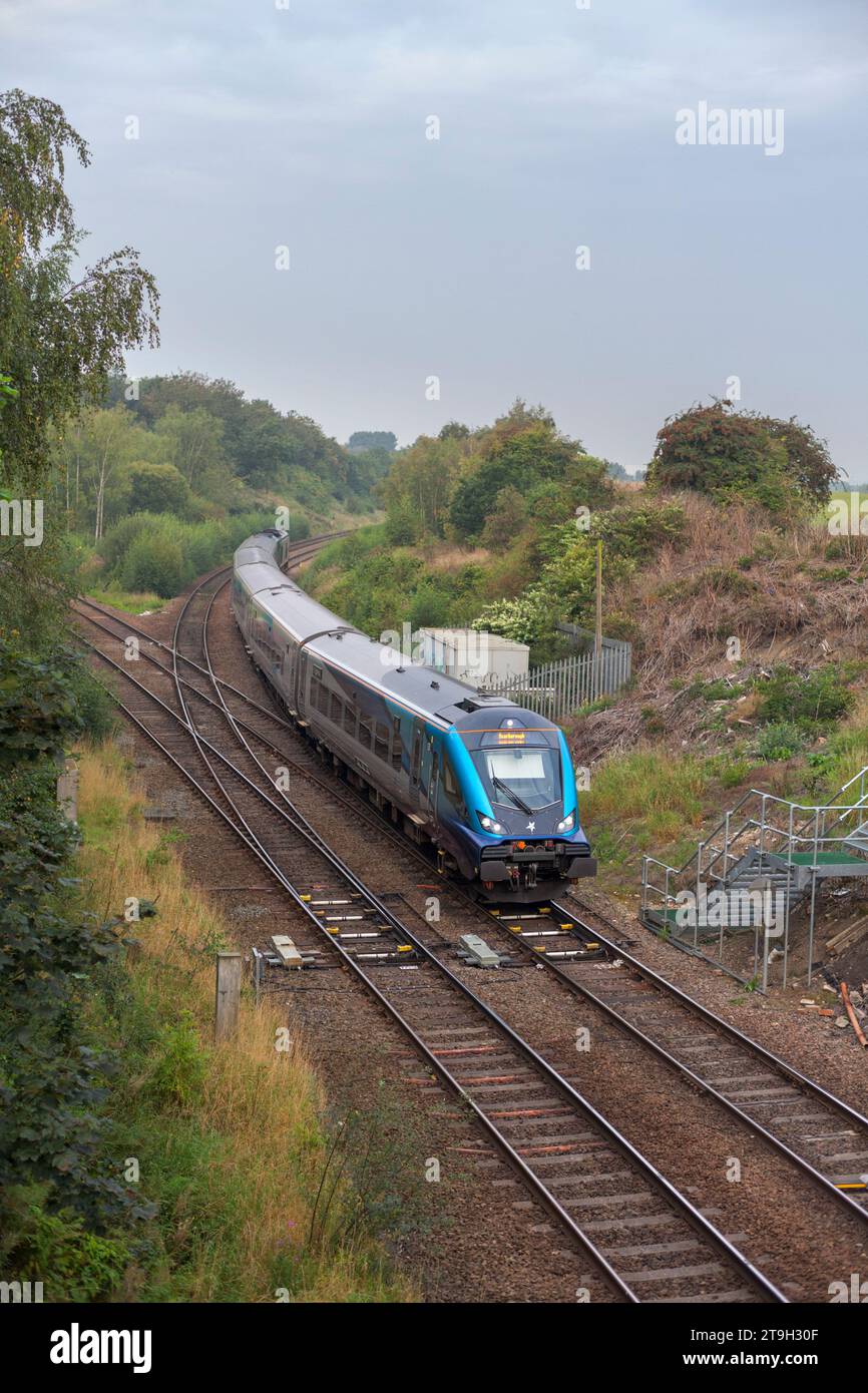 Transpennine Express Nova 3  train passing Whitwood Junction, Castleford, Yorkshire with a diamond crossing in the foreground Stock Photo