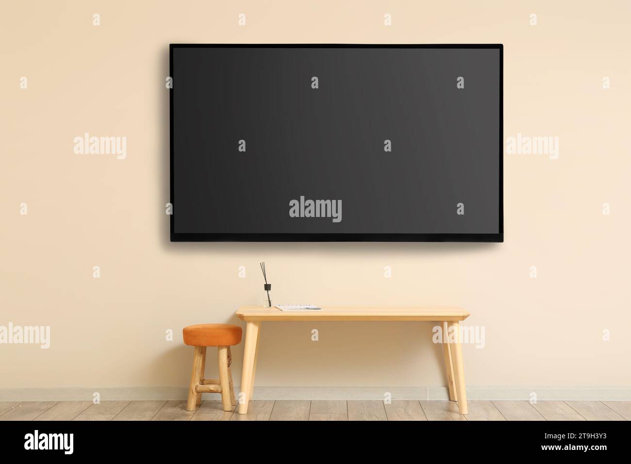 Modern smart TV set hanging on beige wall in room Stock Photo - Alamy