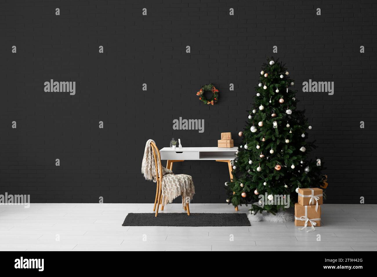 Beautiful Christmas tree with gifts, table and chair sofa near dark wall. Banner for design Stock Photo
