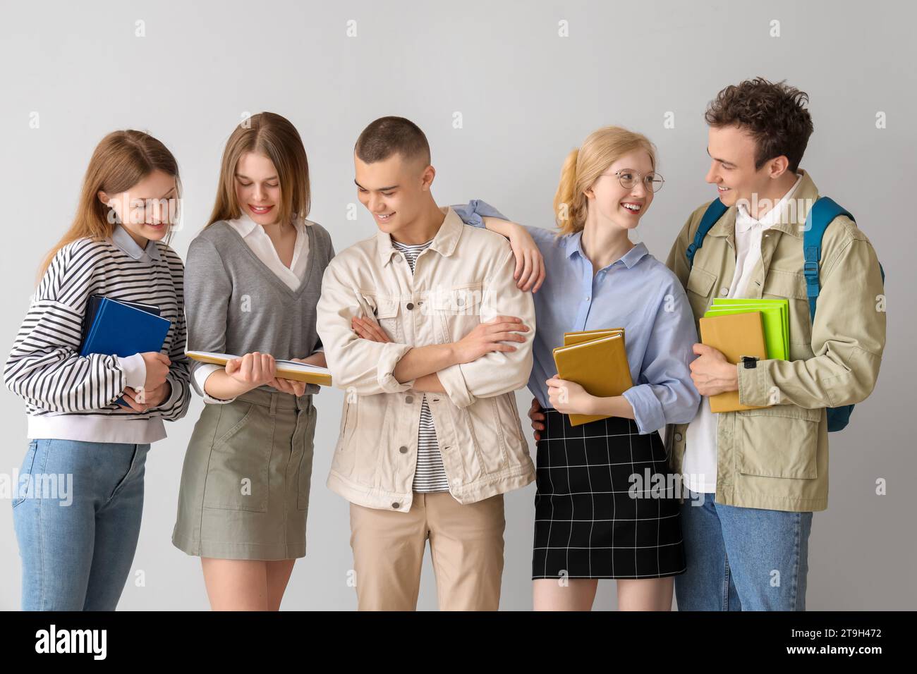 Group of students with books on grey background Stock Photo - Alamy
