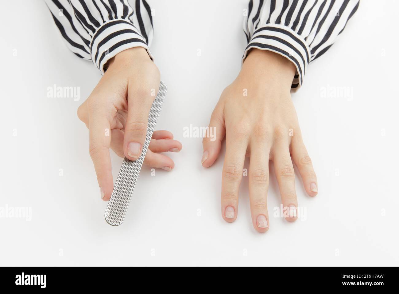 Woman filing damaged nails. Fingernails with onycholysis after removing gel polish Stock Photo