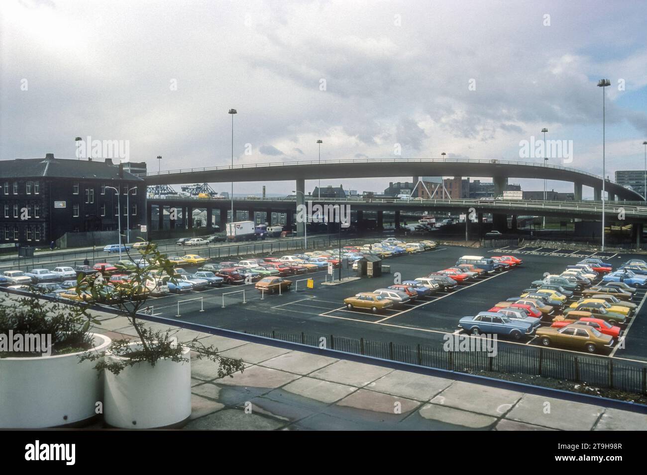 1977 archive photograph of car parking in central Glasgow. Onramp to