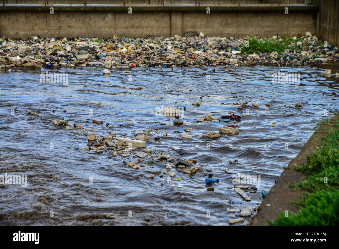Nakuru, Kenya. 25th Nov, 2023. Plastic waste of all kind drifts on a storm water channel that