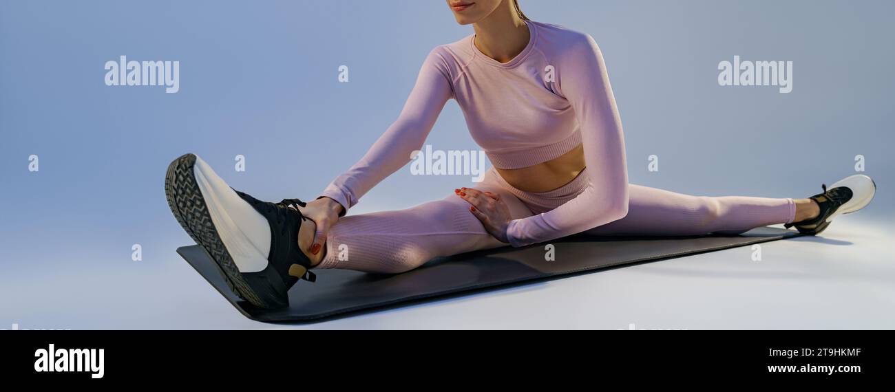Sporty woman doing stretching exercises on yoga mat on studio ...