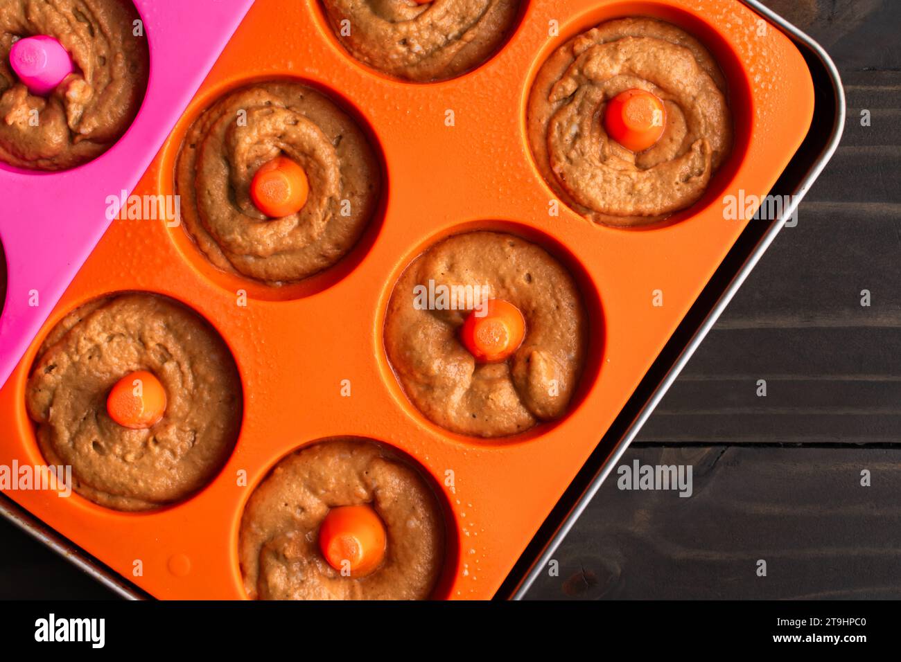 Baked Apple Cider Donut Batter in Silicone Donut Molds: Pastry batter that has been piped into silicone doughnut molds ona sheet pan Stock Photo