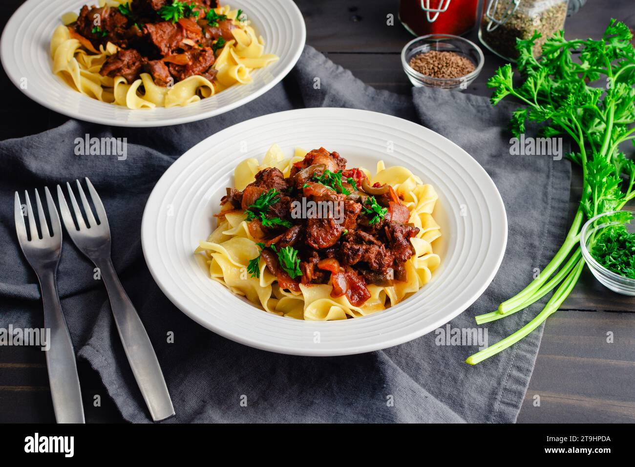 German Goulash Served Over Egg Noodles in Shallow Bowls: Simmered