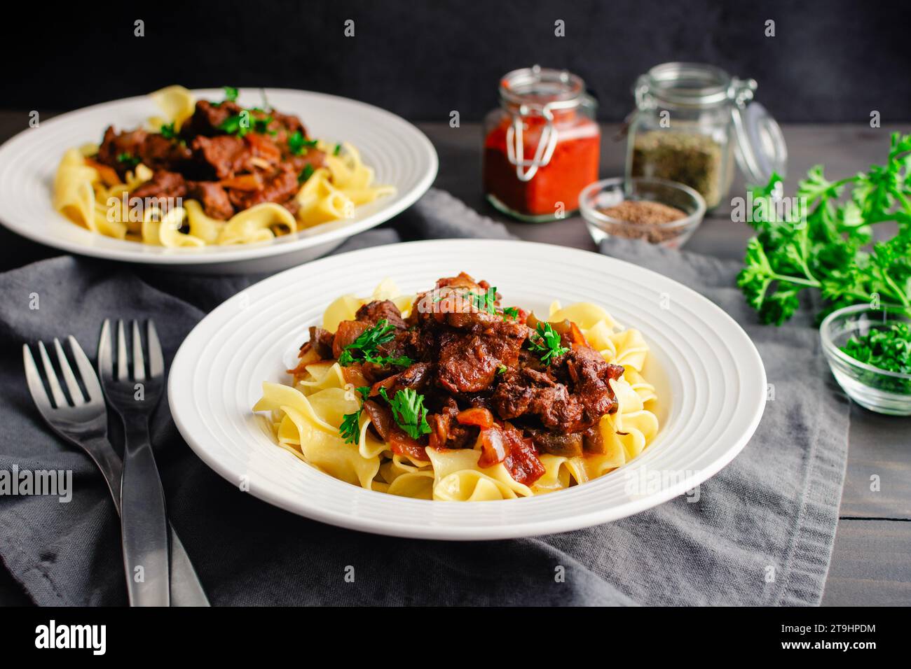 German Goulash Served Over Egg Noodles in Shallow Bowls: Simmered