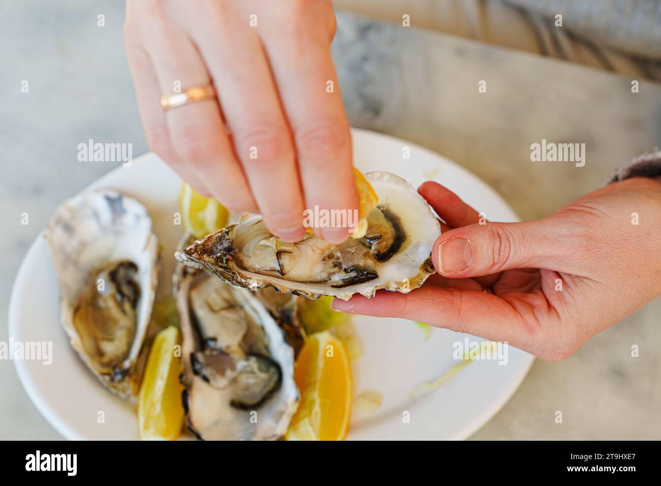 Girl enjoying gourmet delicacy with oysters, lemons, and silver