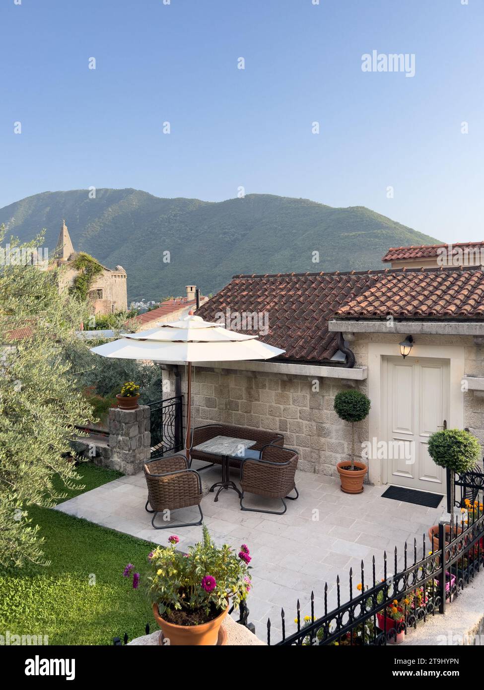 Cozy courtyard of an old stone house with a table and wicker chairs ...