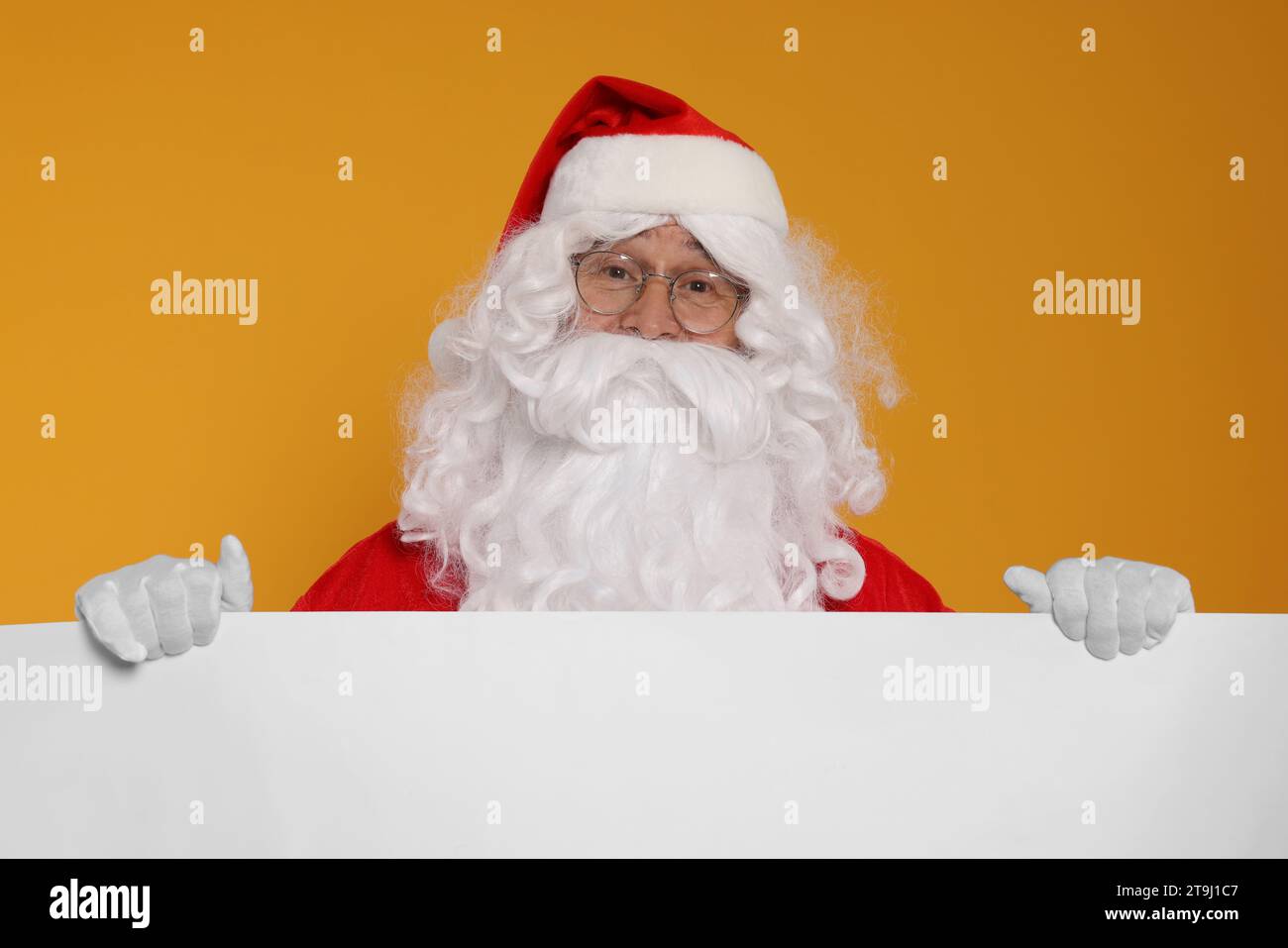Santa Claus holding blank poster on orange background Stock Photo - Alamy