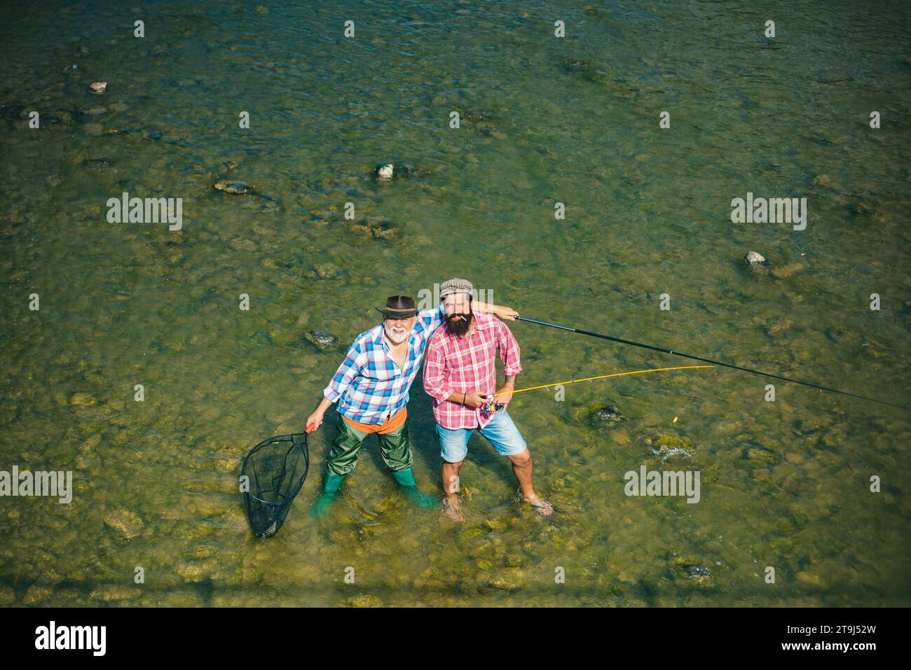 Two men friends fisherman fishing on river. Old father and son with rod ...