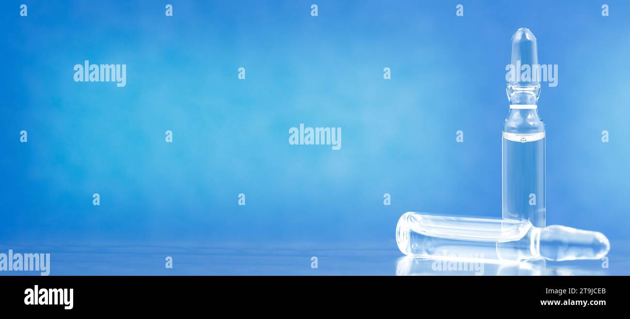 Two medical ampoules with solution for injection on blue background. Space for text Stock Photo