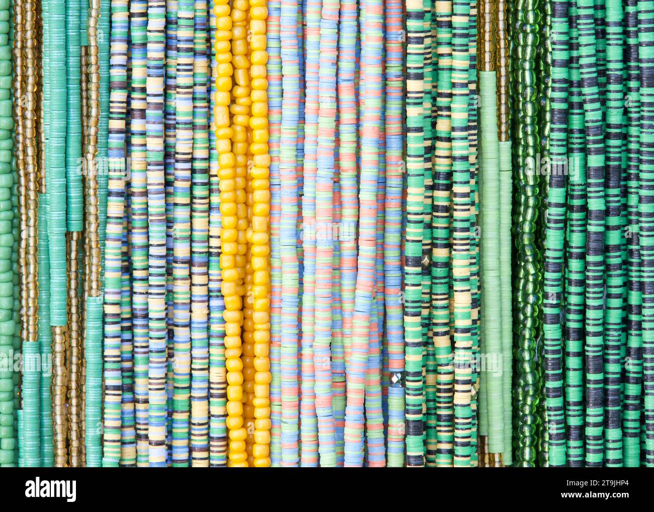 close up on strings of beads in Green and yellows. Popular hair