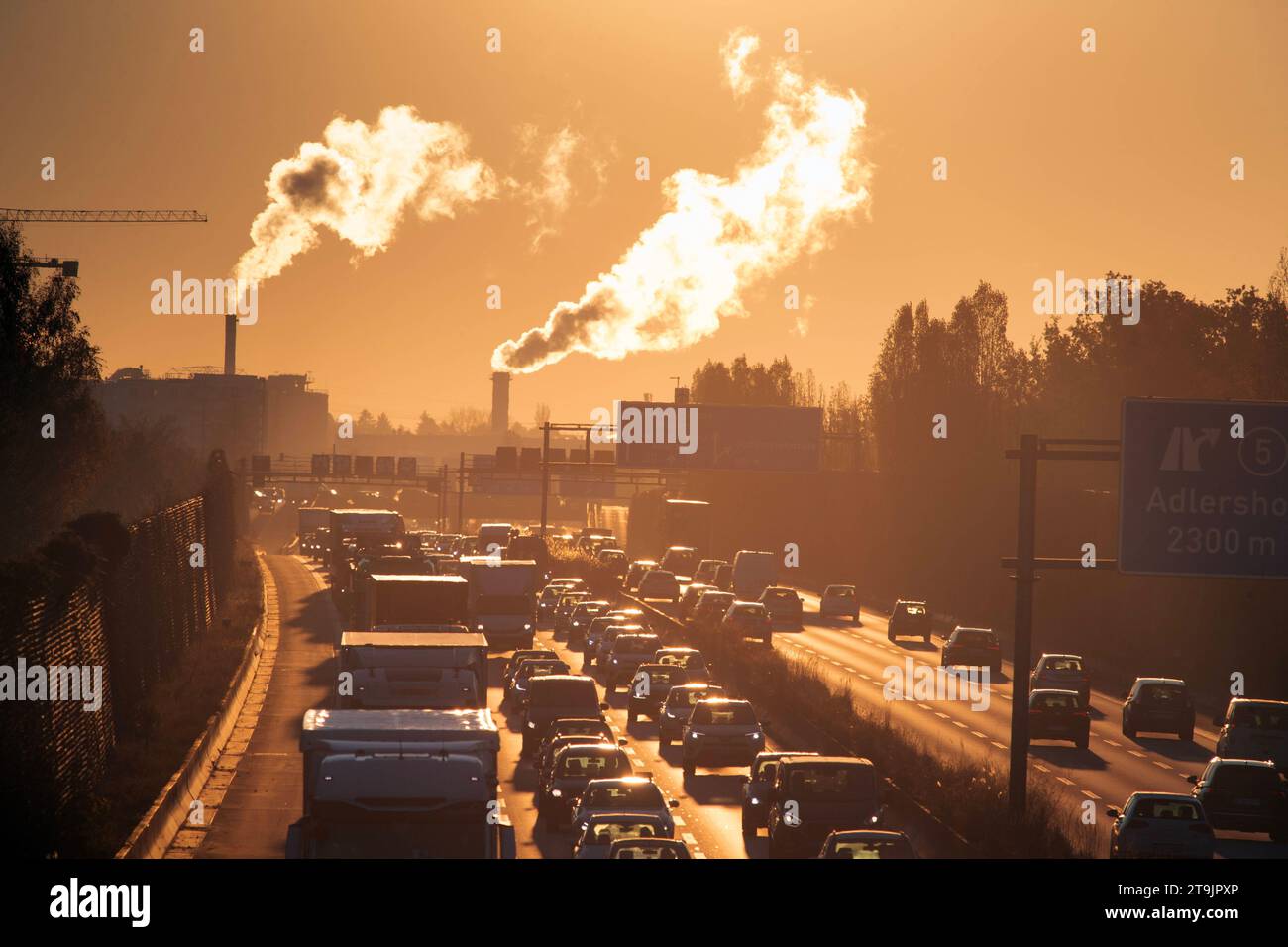 22.11.2023, Berlin, GER - Stau am Morgen auf der A113 stadteinwaerts in Hoehe Abfahrt Johannisthaler Chaussee. A113, Abgase, Abgaswolken, Abwaerme, Alltag, aussen, Aussenaufnahme, Autobahn, Automobile, Autos, Autoverkehr, BAB 113, Berlin, Berufsverkehr, CO2, CO2-Ausstoss, deutsch, Deutschland, dreispurig, Europa, europaeisch, Fahrbahn, Fahrzeuge, Gedraenge, gedraengt, Gegenlicht, Gegenlichtaufnahme, Gesellschaft, Herbst, Individualverkehr, Industrieschornsteine, Jahreszeit, Johannisthaler Chaussee, Kraftfahrzeuge, Laster, Lastkraftwagen, LKW, Luftverschmutzung, mehrspurig, Morgen, morgens, Per Stock Photo