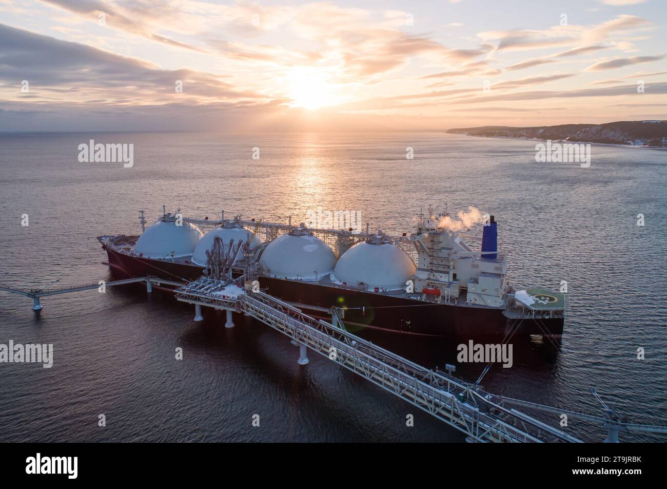 Aerial of Liquified Natural Gas LNG carrier moored to a small gas terminal. Fuel crisis. Sanctions. Stock Photo