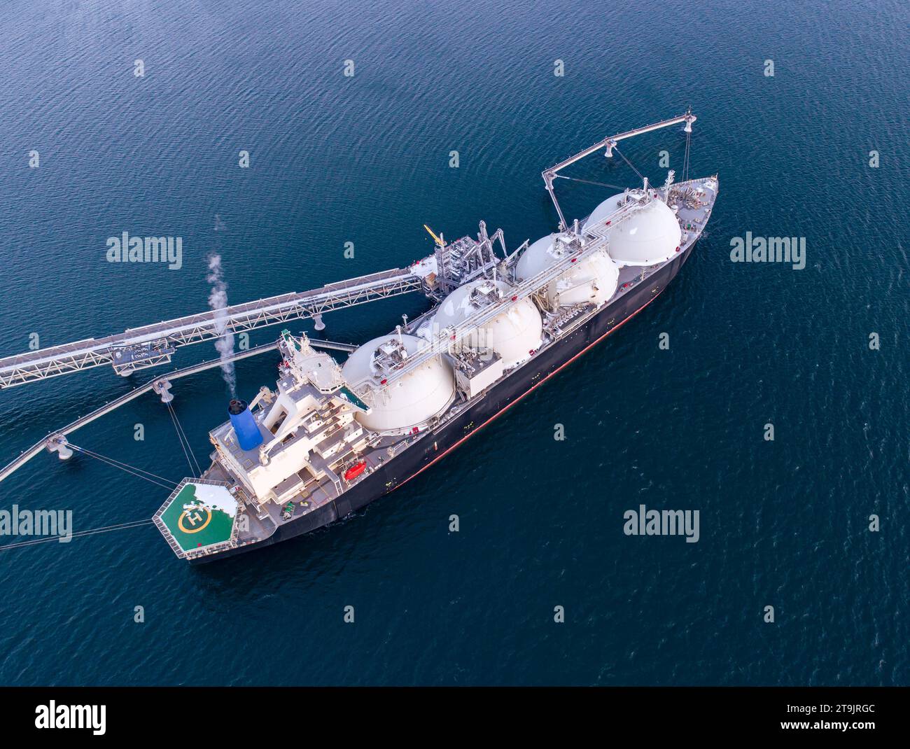 Aerial of Liquified Natural Gas LNG carrier moored to a small gas terminal. Fuel crisis. Sanctions. Stock Photo