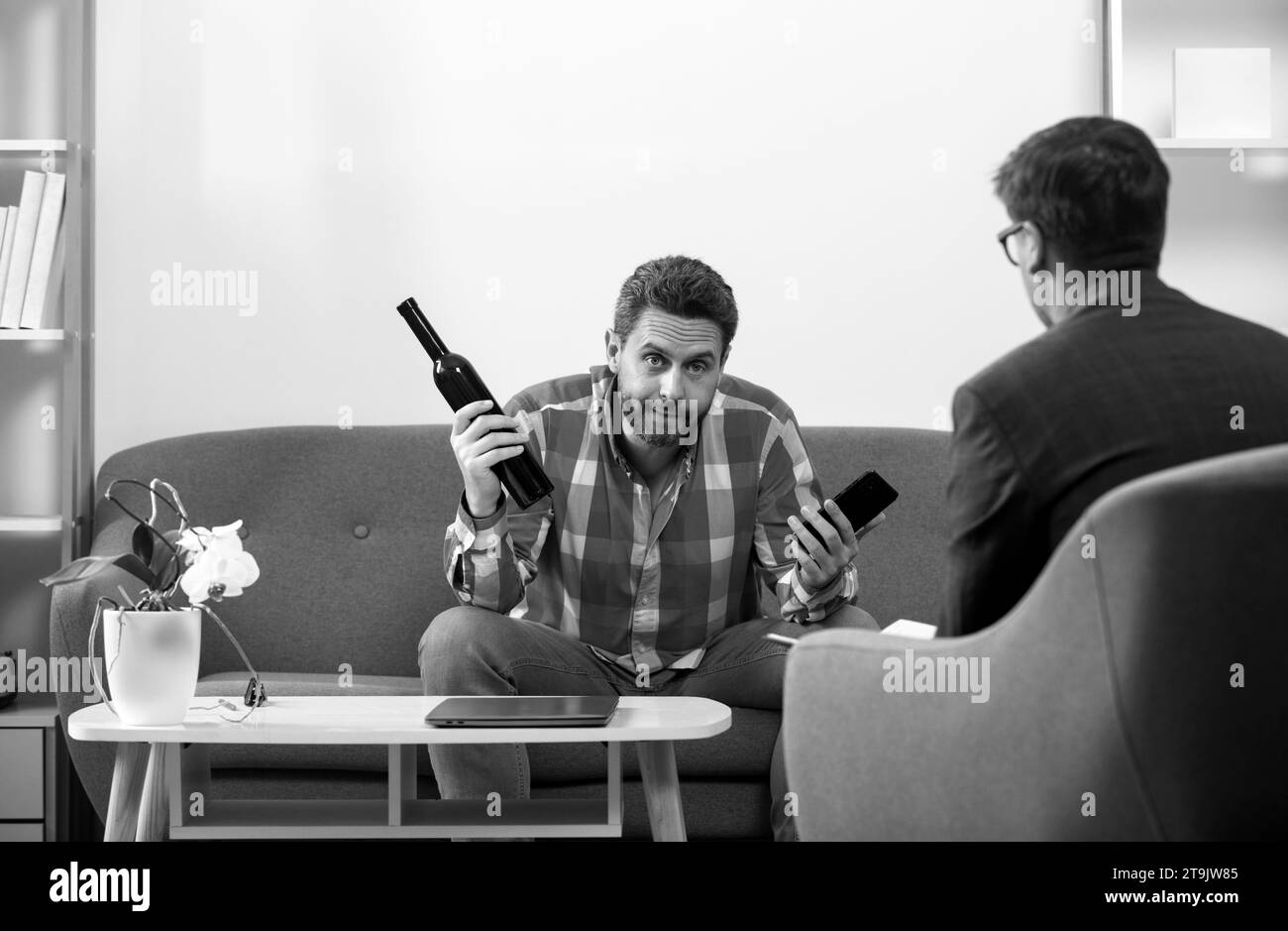 Upset man alcoholic sitting at psychologist on psychotherapy session