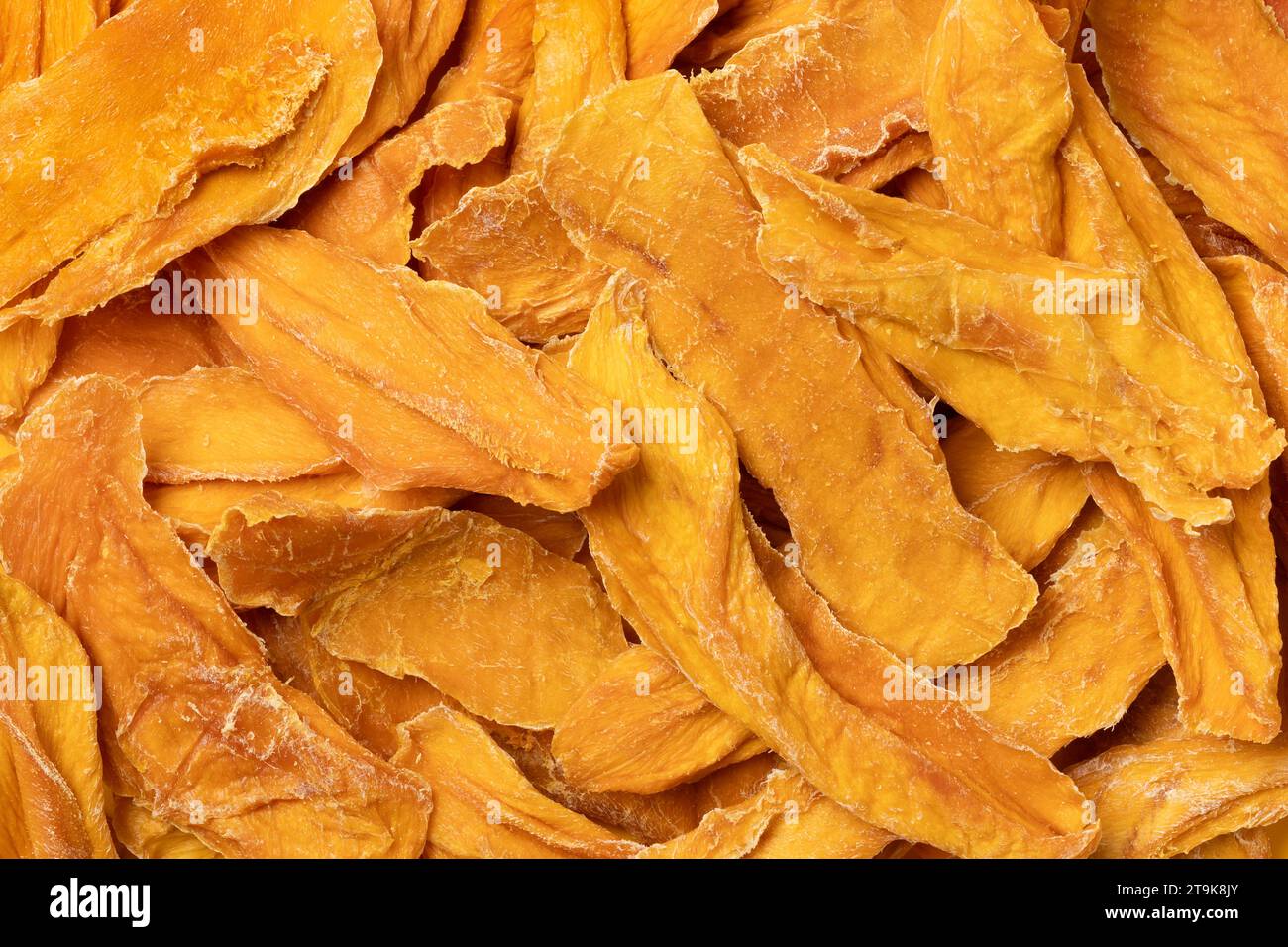 Healthy unsweetened dried mango chips without added sugar close up full frame as background