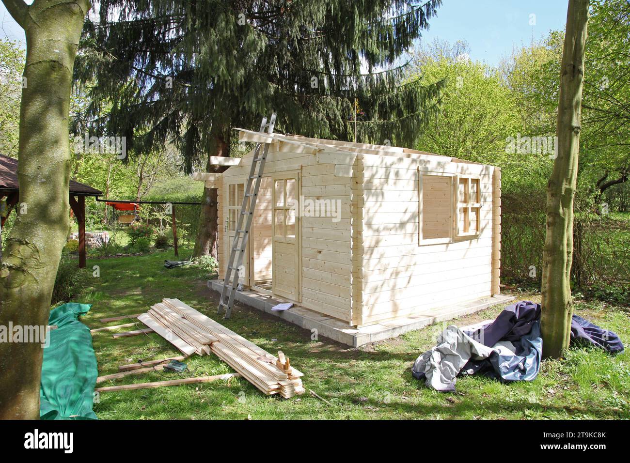 Gartenhaus im Garten neu aufbauen mit Brettern und Balken Stock Photo