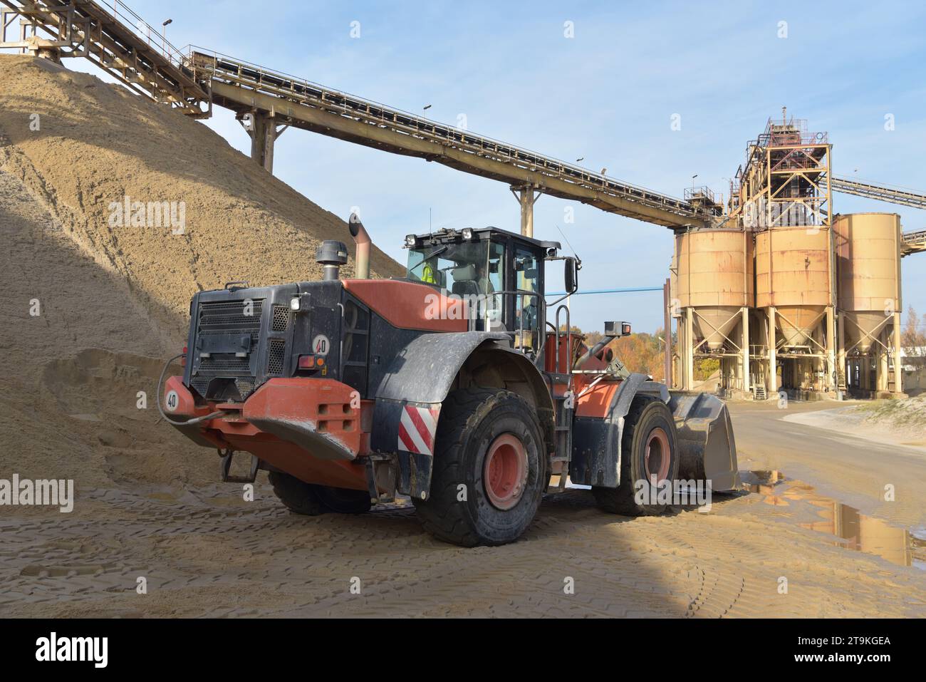 Wheel loader loads truck with gravel in a sand pit - transport and mining of building materials for the construction industry Stock Photo
