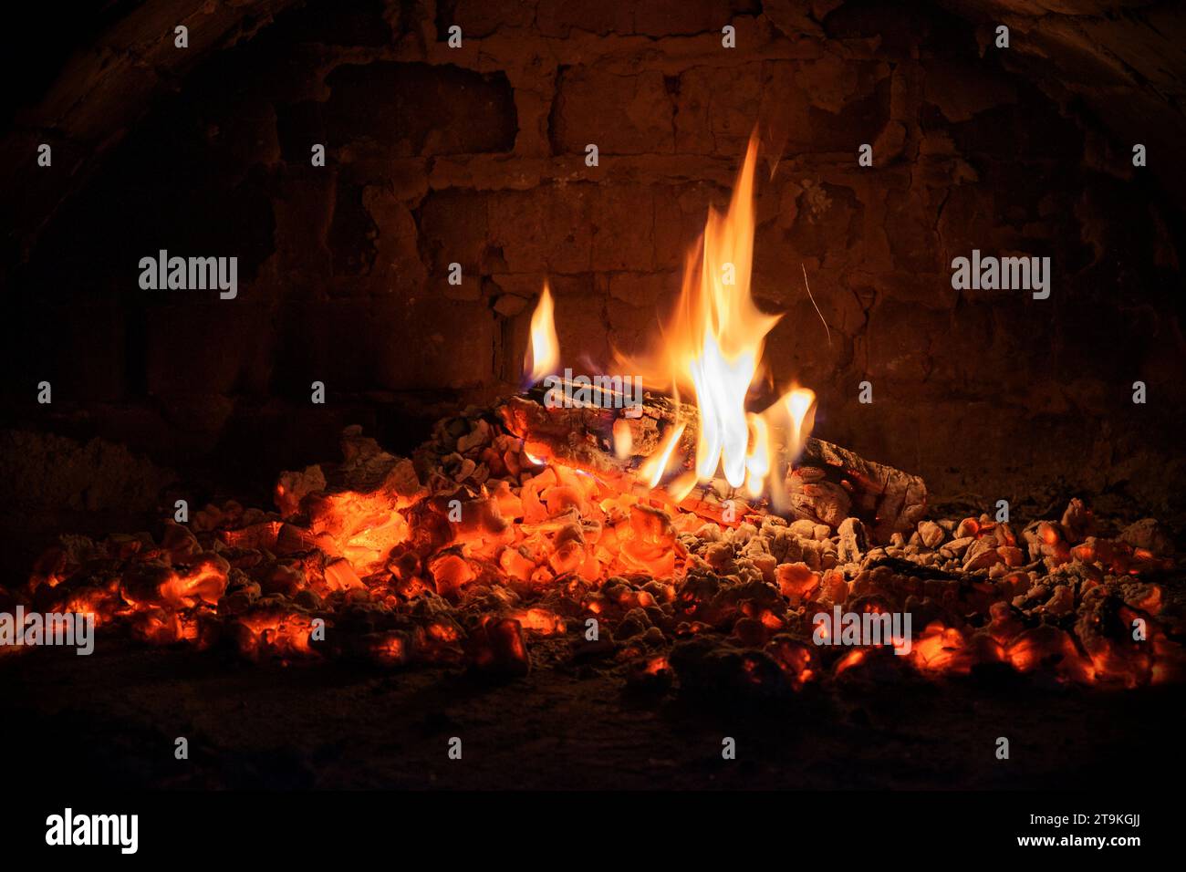 Logs of firewood burn out in the oven. Coals and flames in the