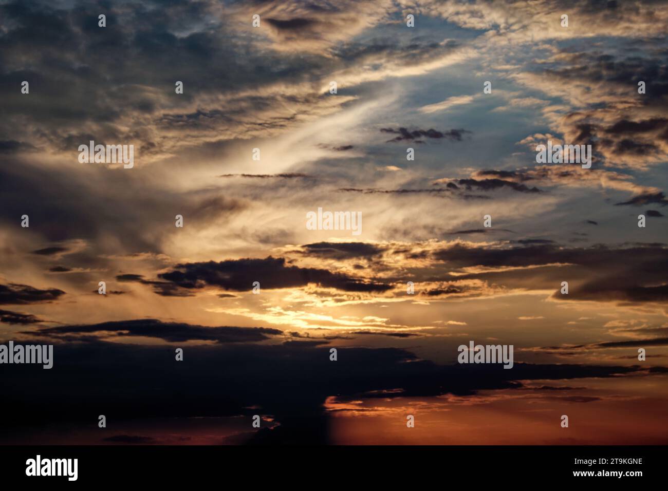 The sun setting behind dark clouds in the sky Stock Photo - Alamy