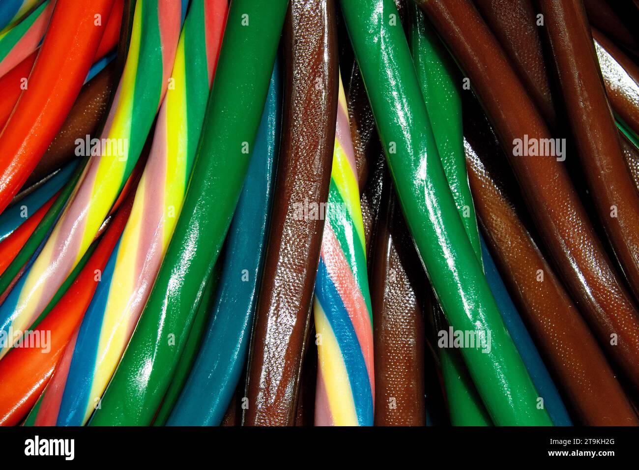 a top-down view of colorful candy sticks in red, green, blue, yellow, and orange, arranged in a pattern. Stock Photo