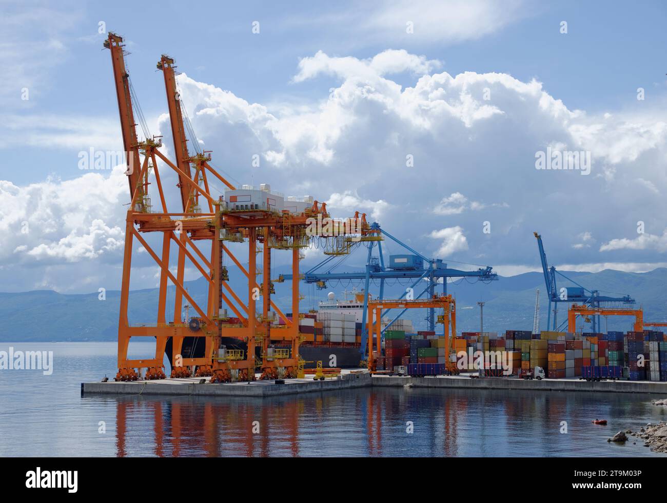 Cargo container ship docked and loaded, with cranes Stock Photo - Alamy