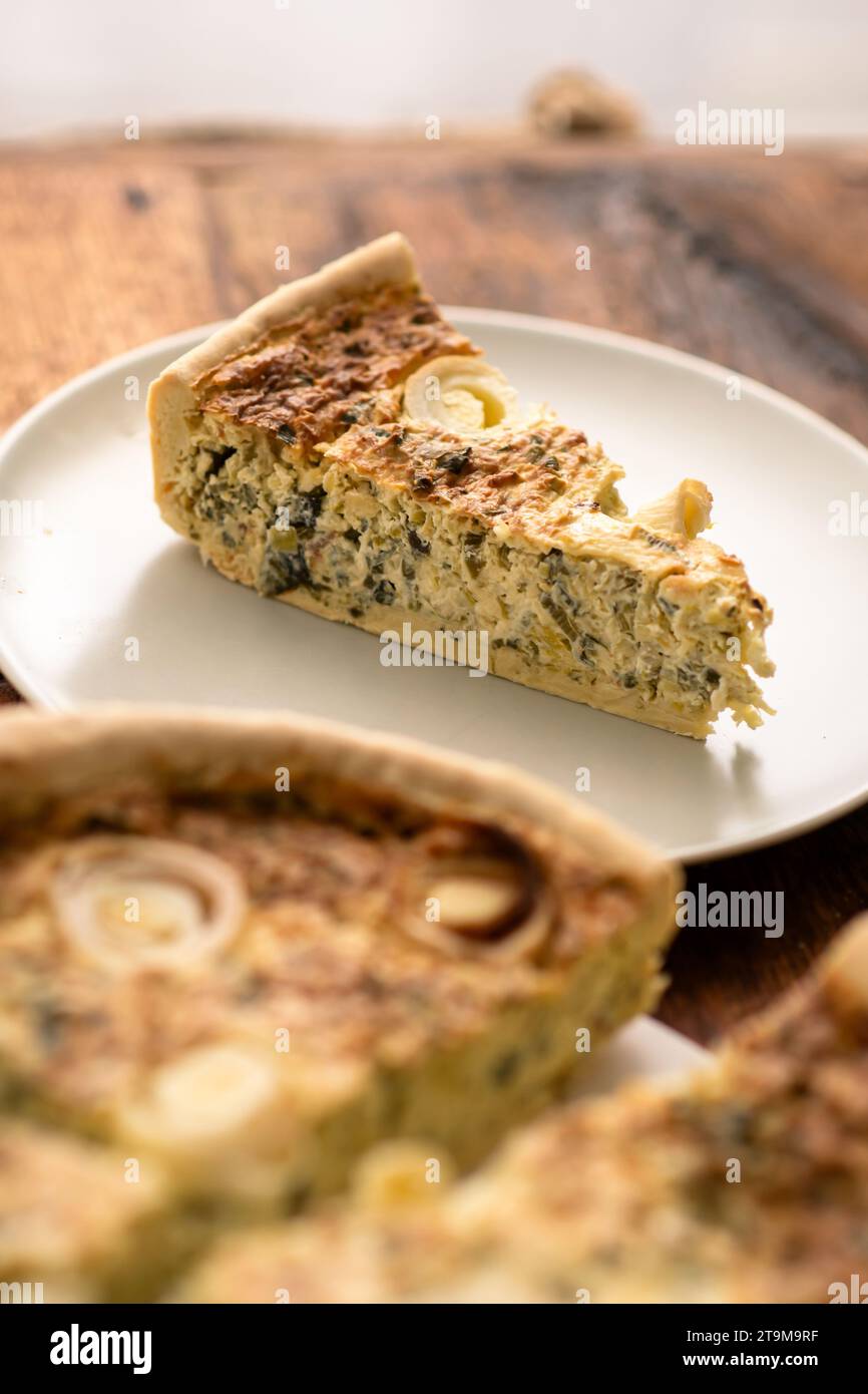 Culinary Artistry: The culinary artistry unfolds with a round leek and egg tart showcased on a wooden tabletop Stock Photo