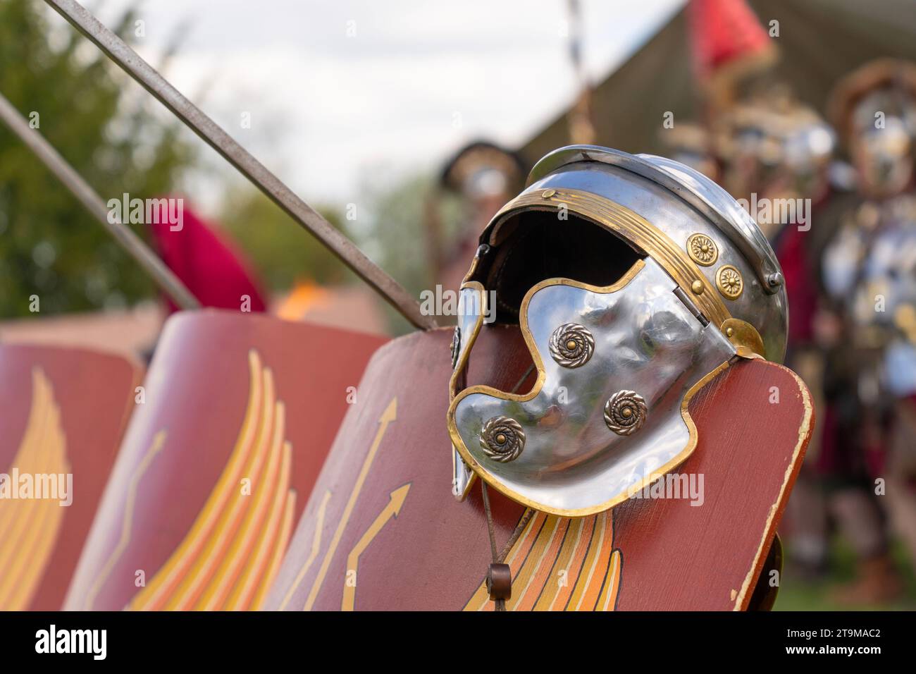 Ancient Roman legionary helmet on a red legionary shield Stock Photo