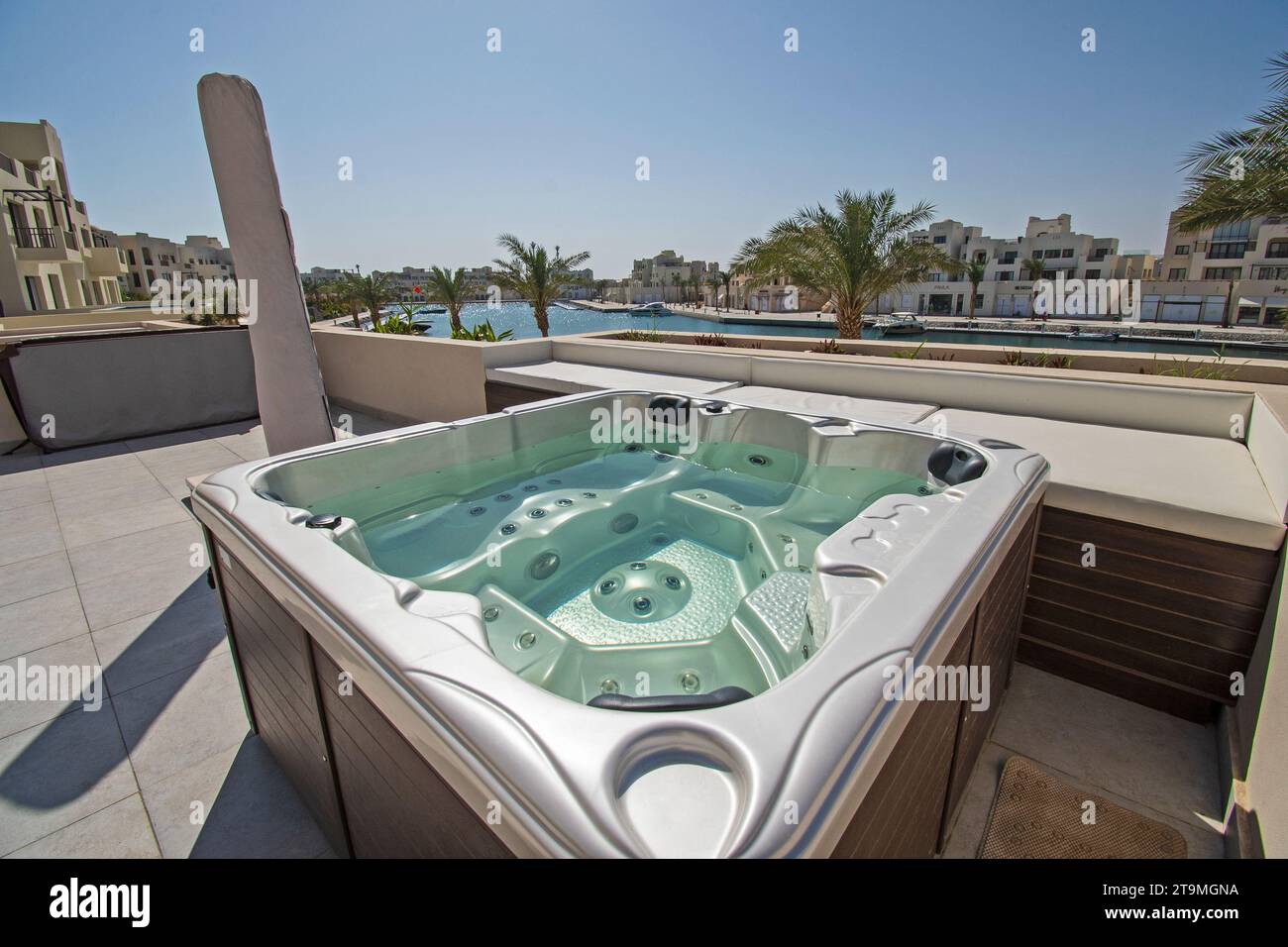 Roof terrace patio furniture at a luxury holiday villa in tropical resort with hot tub and marina view Stock Photo