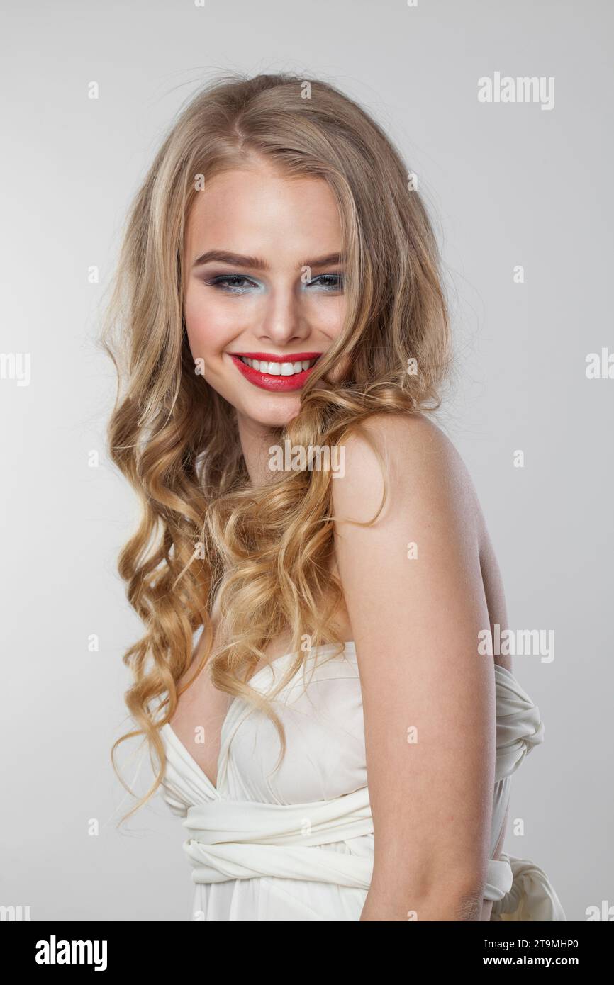 Happy lady with curly hairdo standing on white background. Beauty woman ...