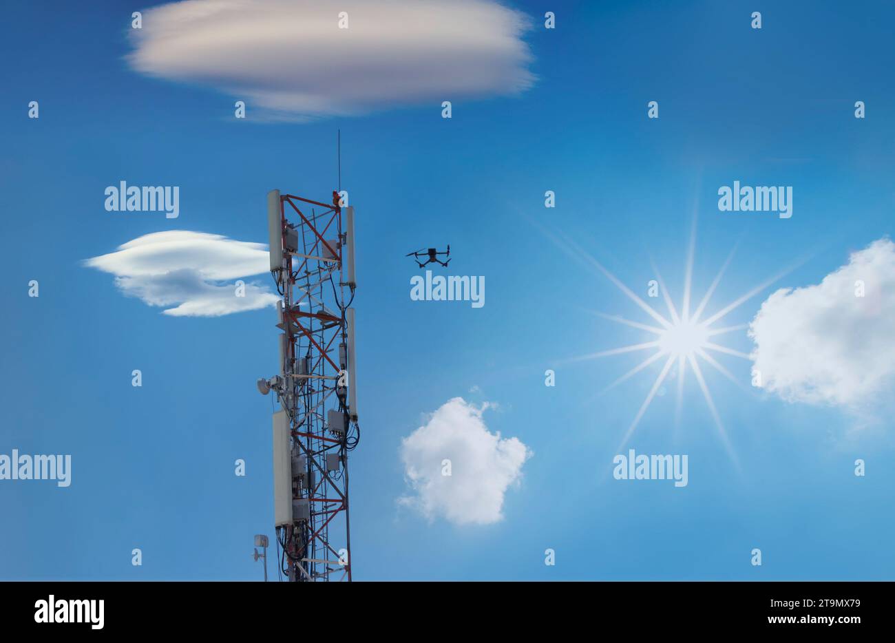 drone inspection cellphone tower, metal mast against the blue cloudy sky in a sunny day Stock Photo