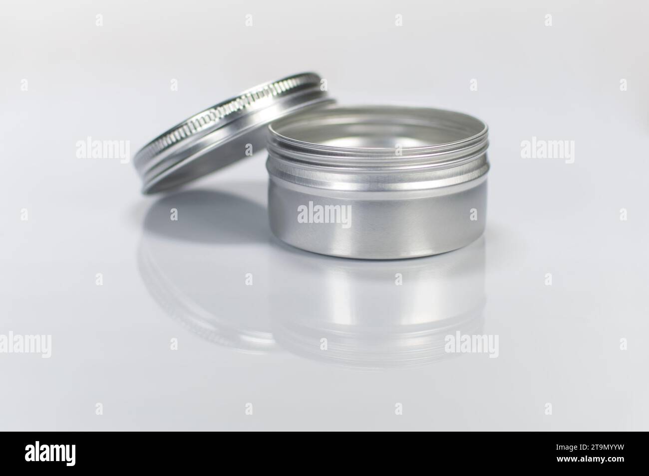 Aluminium tin container with open screw lid. Reflected cutout Stock Photo