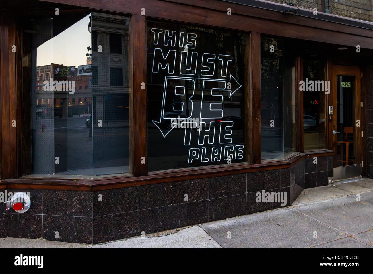 Shop window of a vacant store in Detroit with the neon inscription: 'This must be the place'. Detroit, United States Stock Photo