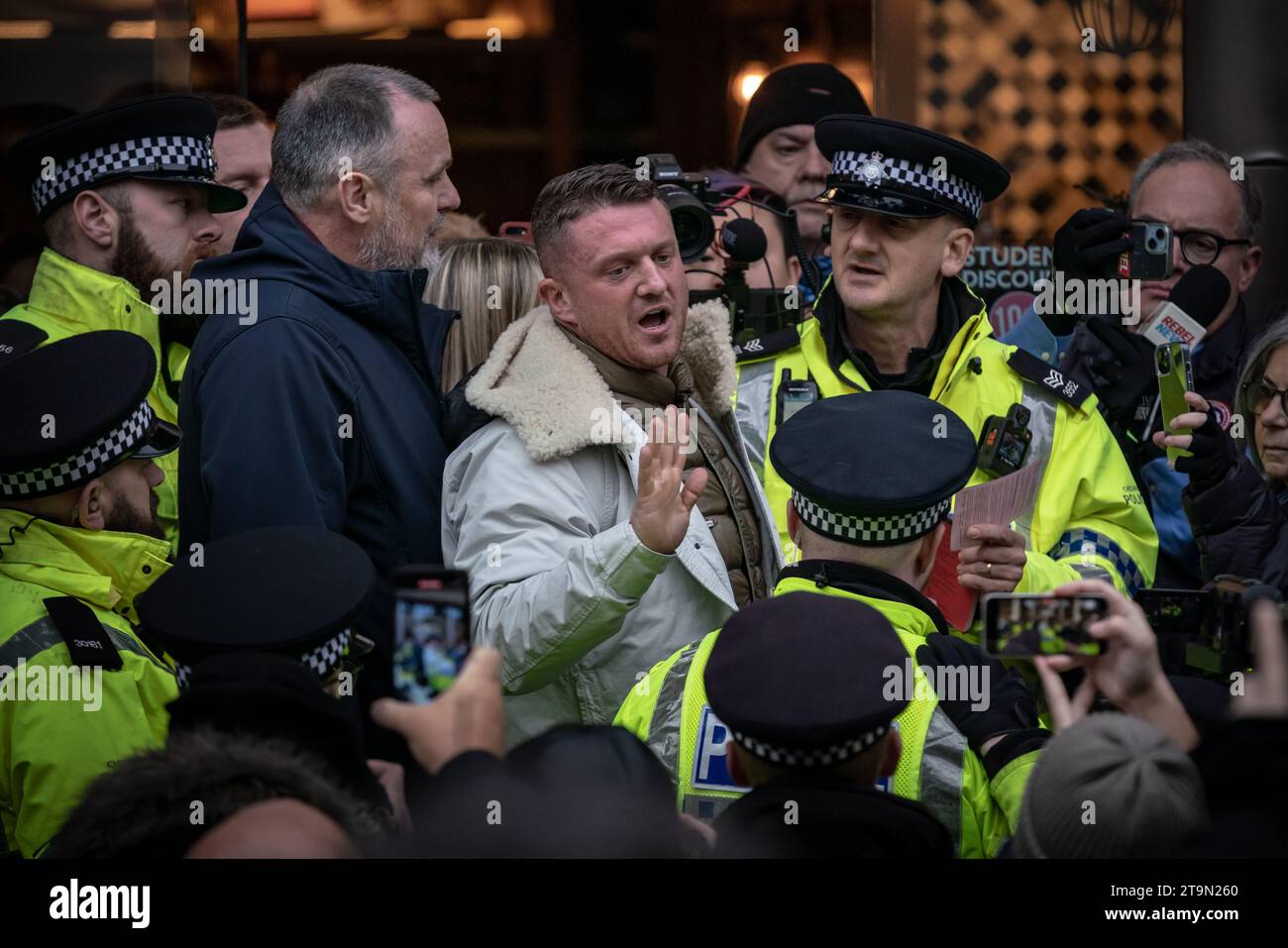 London, UK. 26th November 2023. Tommy Robinson argues with police officers prior to being arrested just before the March Against Antisemitism. The hard-right agitator was in a café opposite the Royal Courts of Justice, the official start point of the demonstration, when officers ordered him to leave over concerns that his presence would “cause harassment, alarm and distress to others”. Credit: Guy Corbishley/Alamy Live News Stock Photo