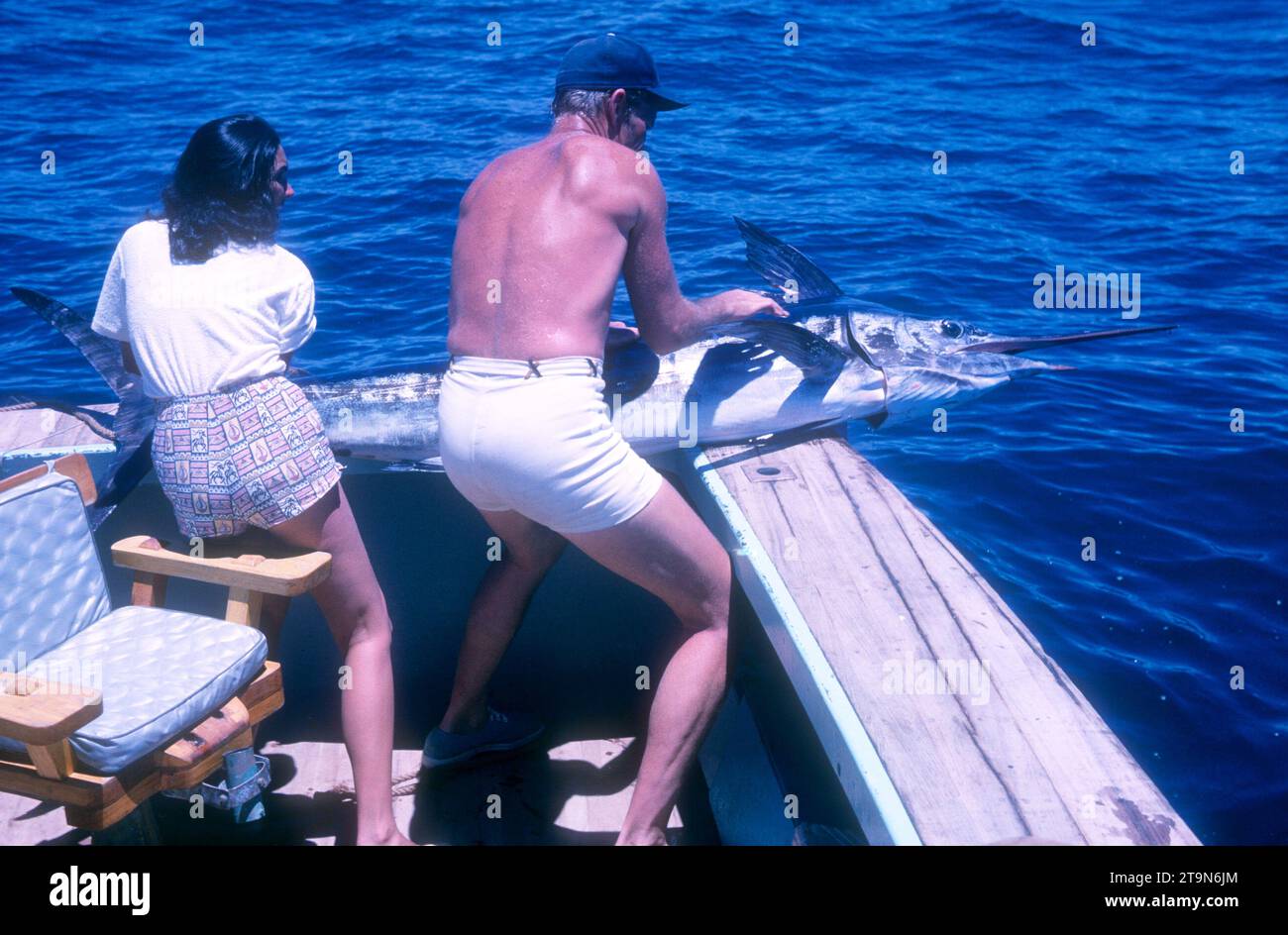 BAJA CALIFORNIA, MEXICO - JUNE, 1962:  Actor and former baseball player Chuck Connors (1921-1992) and actress fiance Kamala Devi (1934-2010) pull a marlin on the boat while on a fishing trip circa June, 1962 in Baja California, Mexico.  (Photo by Hy Peskin) *** Local Caption *** Kamala Devi;Chuck Connors Stock Photo