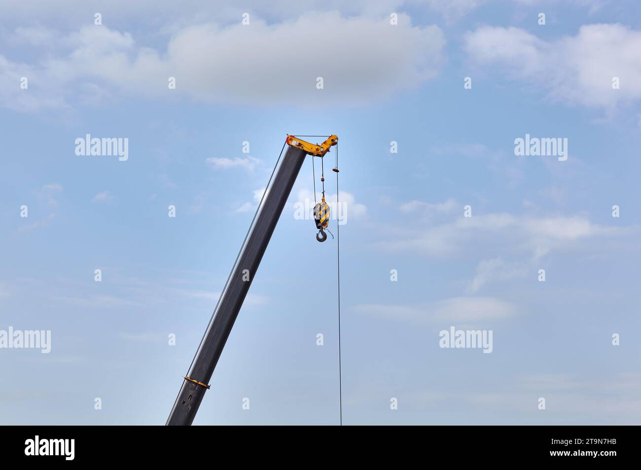 Detail from a floading cargo crane over blue sky background. Boom crane part of mobile crane using to heavy lifting and move object in many industry s Stock Photo