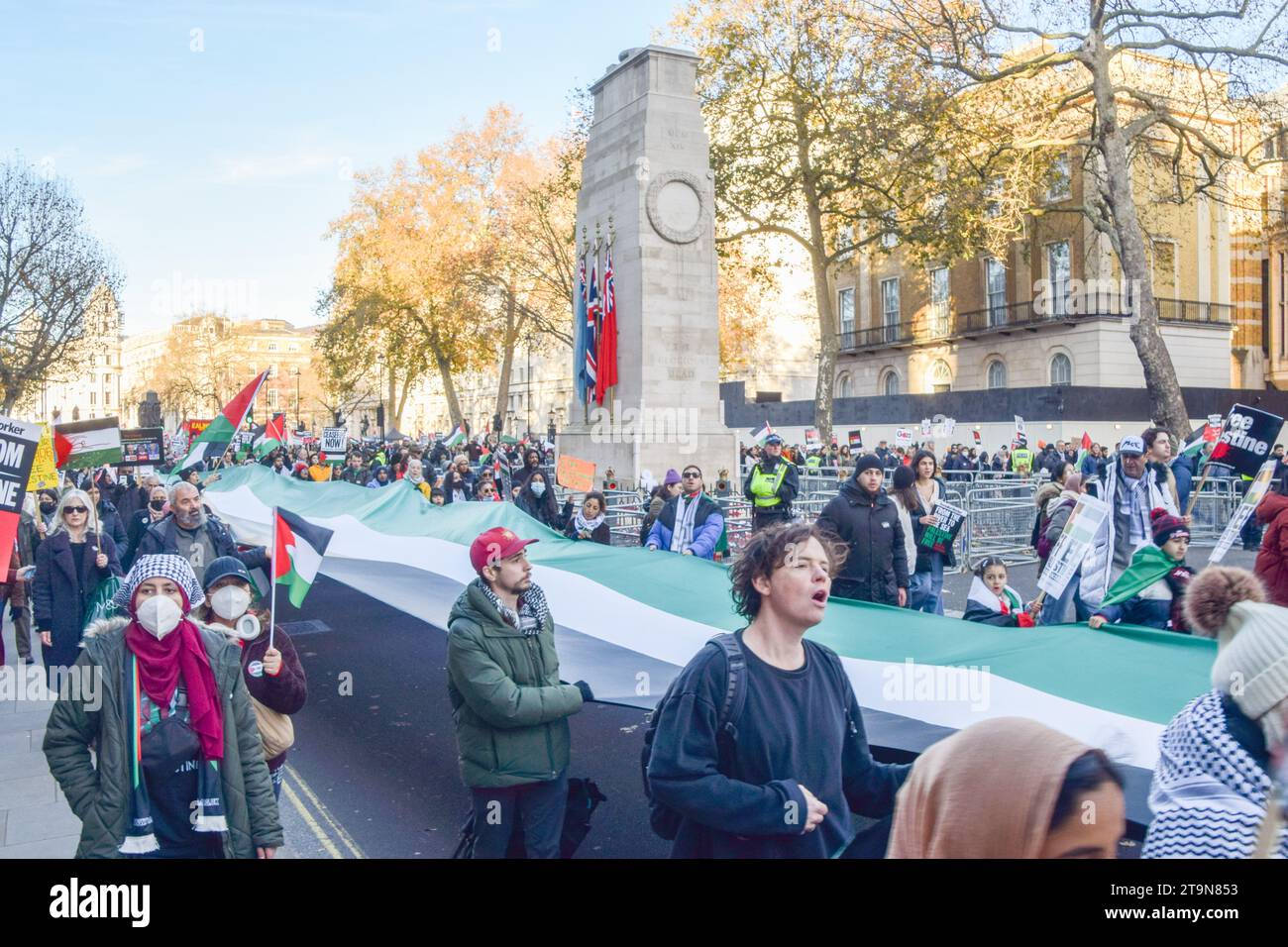 London, UK. 25th November 2023. Protesters pass by The Cenotaph in ...