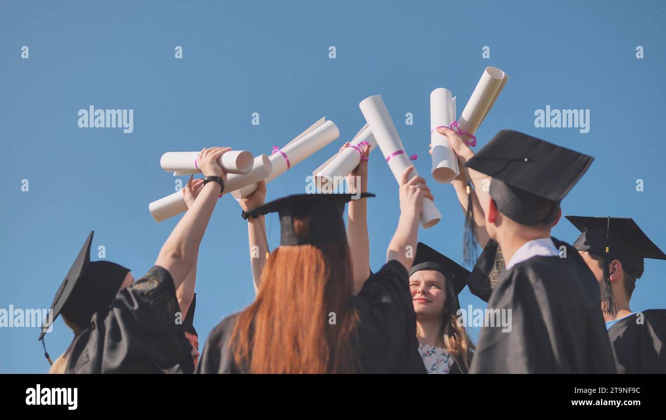 College graduates with caps tie their diplomas together Stock Photo - Alamy